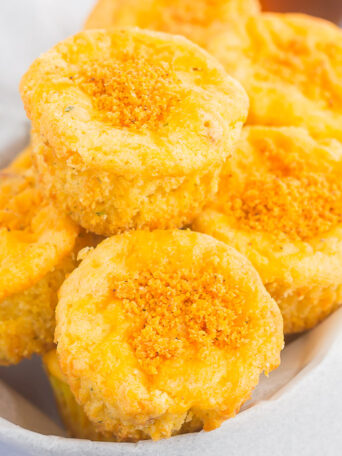 These Cheesy Cornbread Muffins are loaded with flavor and easy to make. Filled with cheddar cheese, zesty spices and baked until golden, these muffins are perfect to serve as a simple side dish or snack!