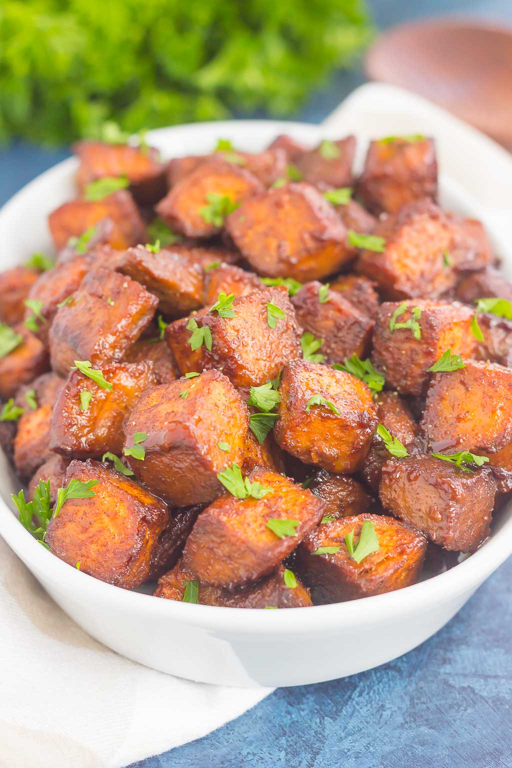 dish of cinnamon brown sugar sweet potatoes garnished with parsley 