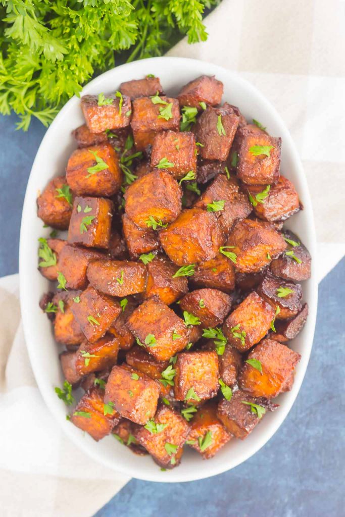 overhead view of dish of cinnamon brown sugar sweet potatoes garnished with parsley