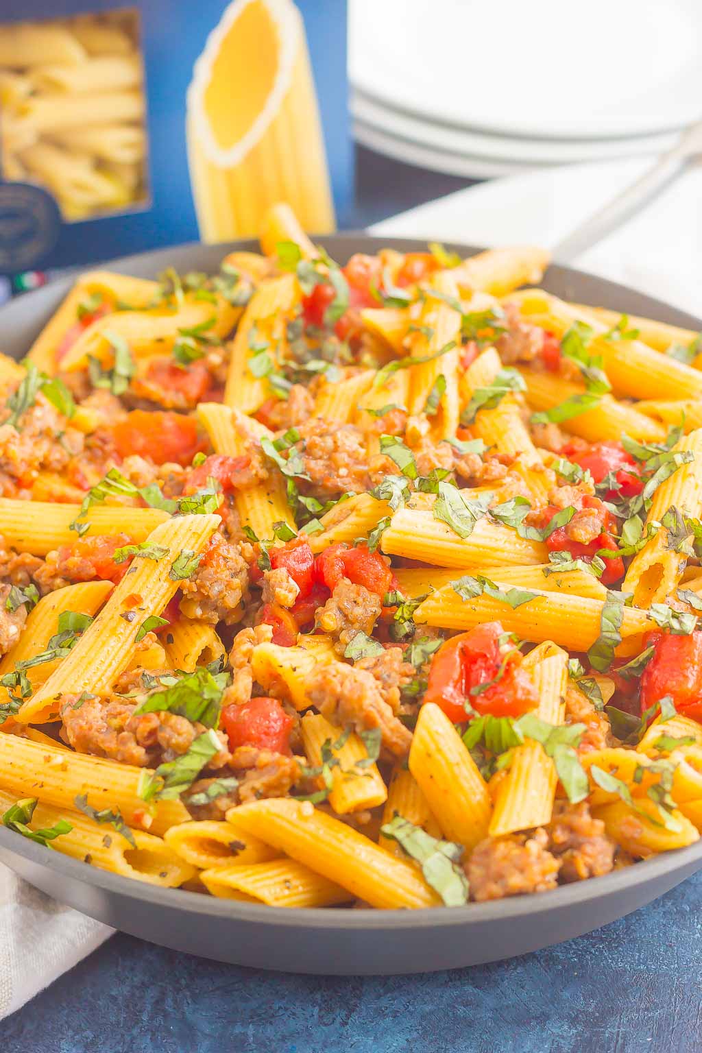 tomato basil pasta with italian sausage in large gray bowl