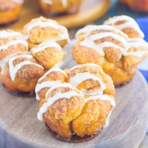 These Pumpkin Spice Monkey Bread Muffins are a simple treat that's perfect for breakfast or dessert. Pre-made dough is rolled in a cozy pumpkin spice blend and then baked in muffin cups. Topped with a sweet pumpkin glaze and great for the holidays, this gooey muffin is sure to impress everyone!