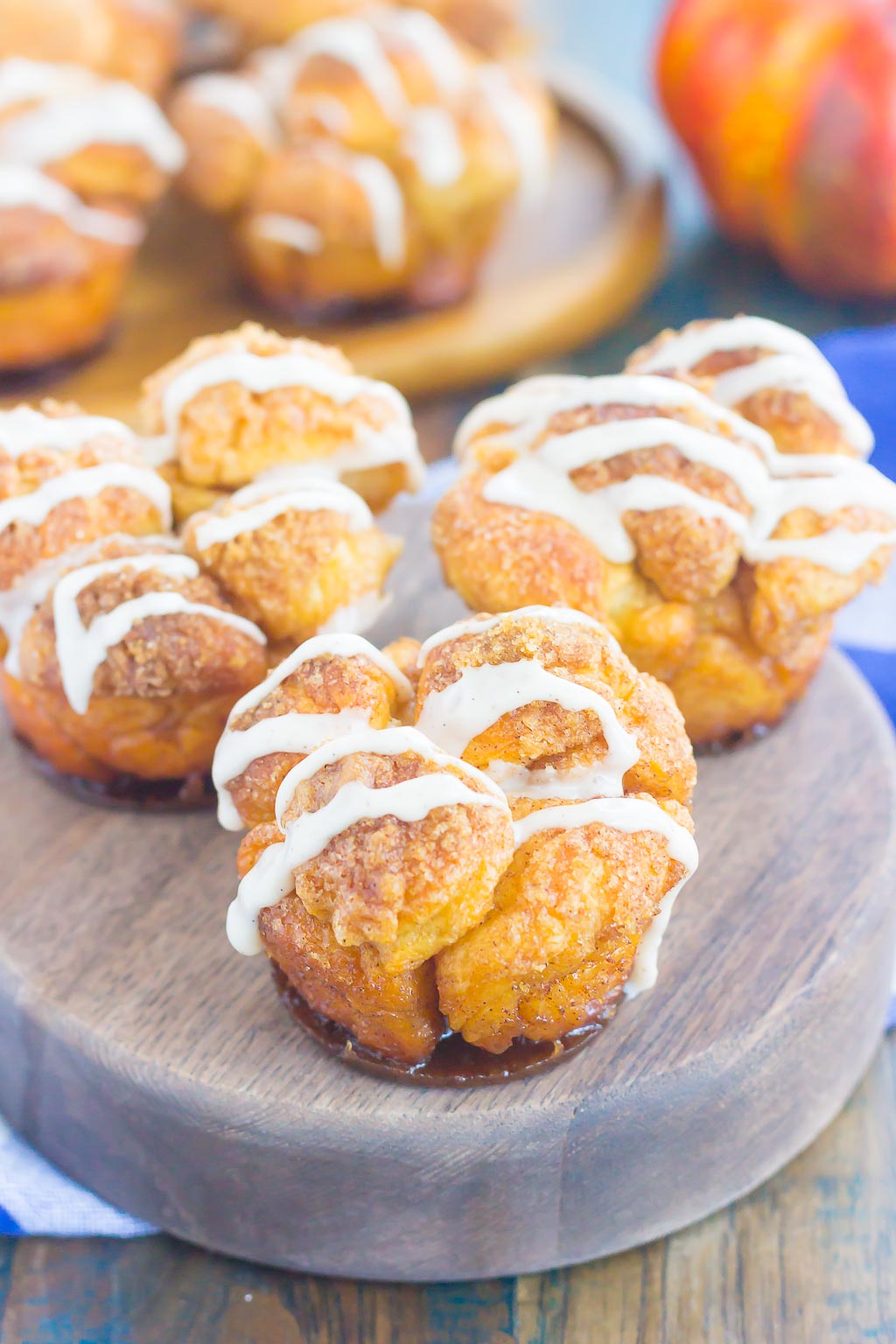 These Pumpkin Spice Monkey Bread Muffins are a simple treat that's perfect for breakfast or dessert. Pre-made dough is rolled in a cozy pumpkin spice blend and then baked in muffin cups. Topped with a sweet pumpkin glaze and great for the holidays, this gooey muffin is sure to impress everyone! #monkeybread #monkeybreadrecipe #pumpkinmonkeybread #pumpkindessert #dessert #falldessert #pumpkinrecipe