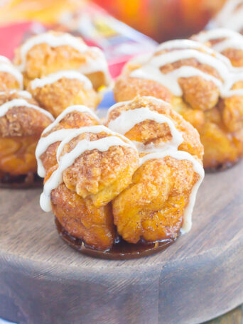 These Pumpkin Spice Monkey Bread Muffins are a simple treat that's perfect for breakfast or dessert. Pre-made dough is rolled in a cozy pumpkin spice blend and then baked in muffin cups. Topped with a sweet pumpkin glaze and great for the holidays, this gooey muffin is sure to impress everyone!