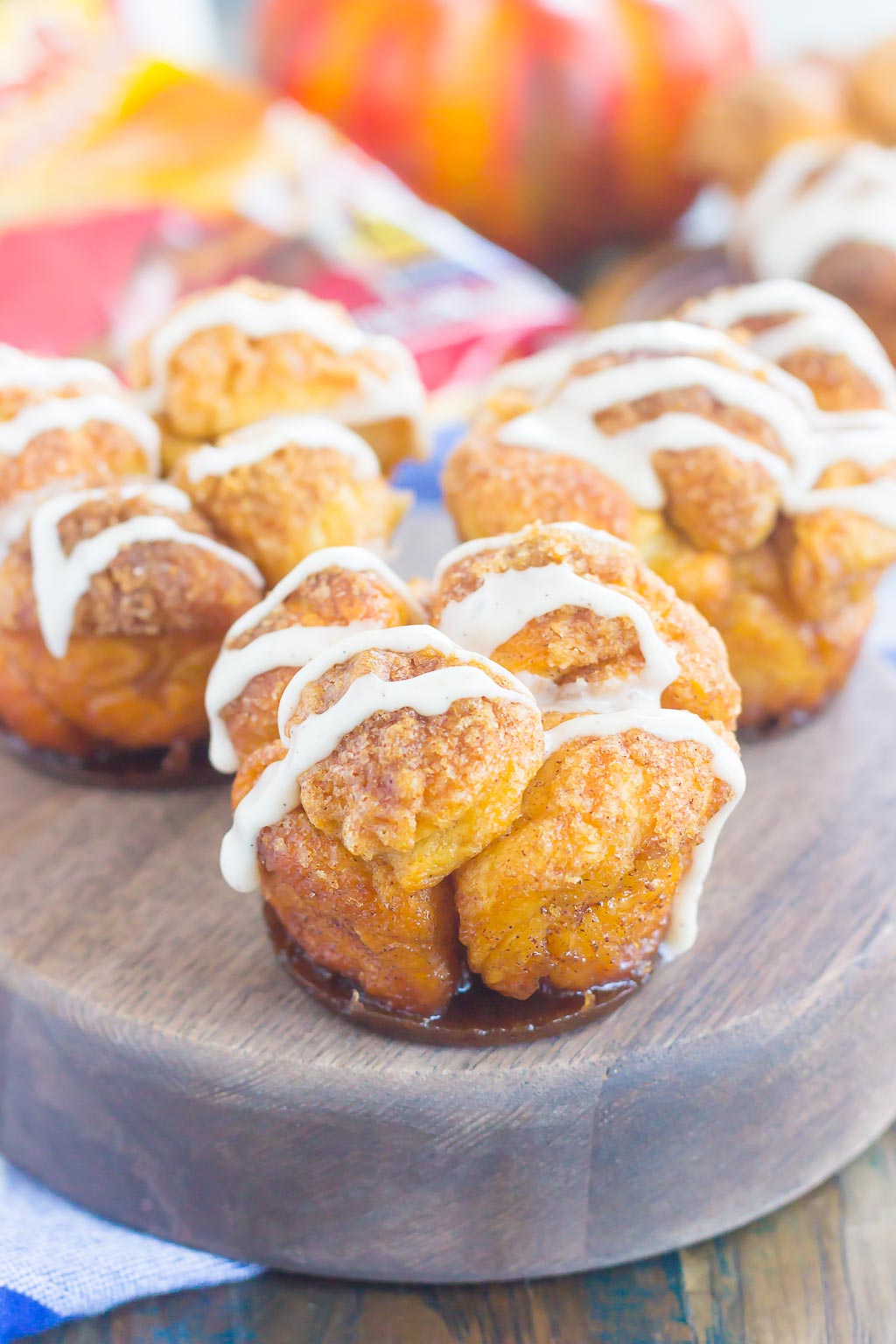These Pumpkin Spice Monkey Bread Muffins are a simple treat that's perfect for breakfast or dessert. Pre-made dough is rolled in a cozy pumpkin spice blend and then baked in muffin cups. Topped with a sweet pumpkin glaze and great for the holidays, this gooey muffin is sure to impress everyone! #monkeybread #monkeybreadrecipe #pumpkinmonkeybread #pumpkindessert #dessert #falldessert #pumpkinrecipe