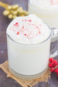 White chocolate hot chocolate in a mug garnished with whipped cream and peppermint candy 