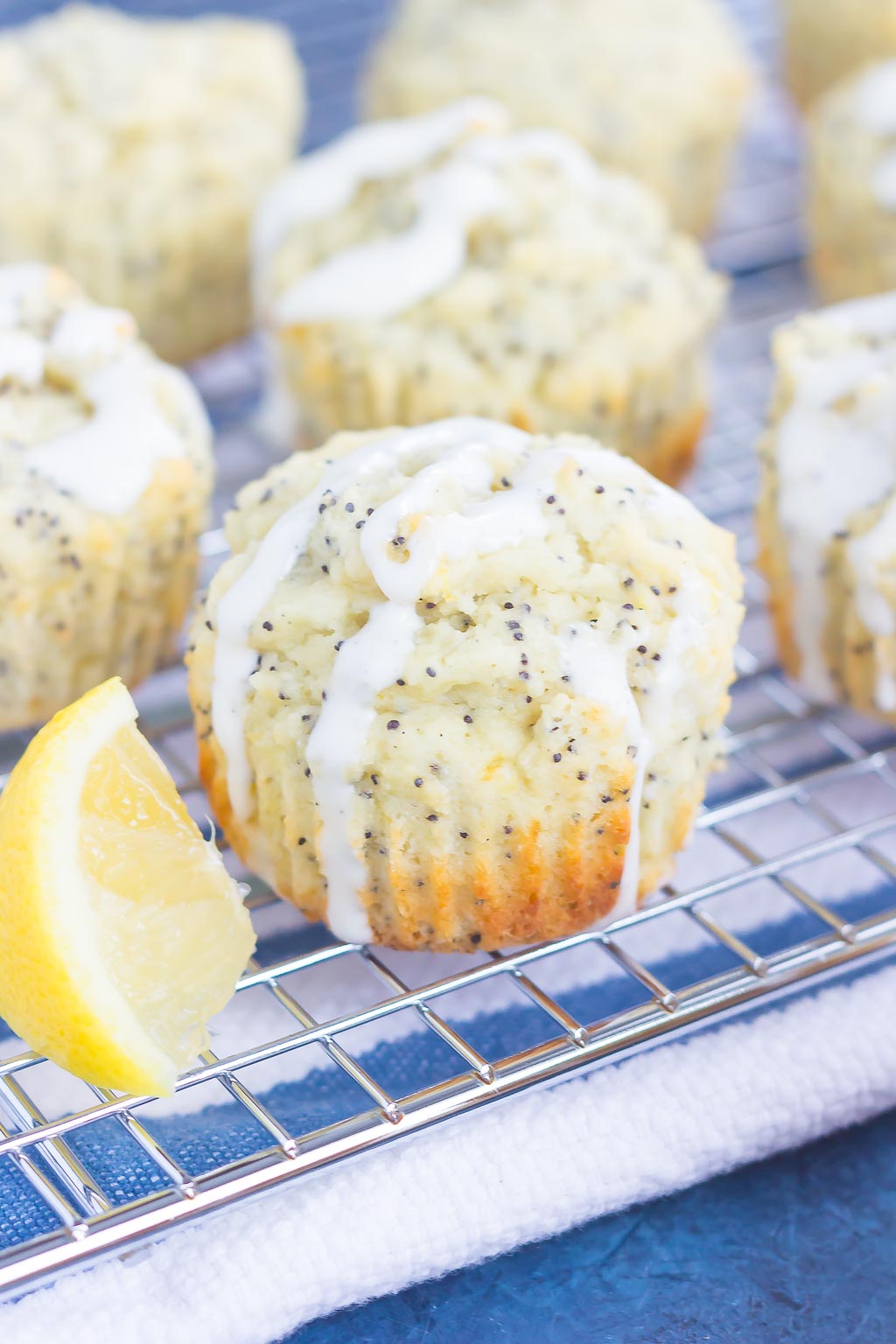 Glazed lemon poppy muffins on a wire cooling rack. 