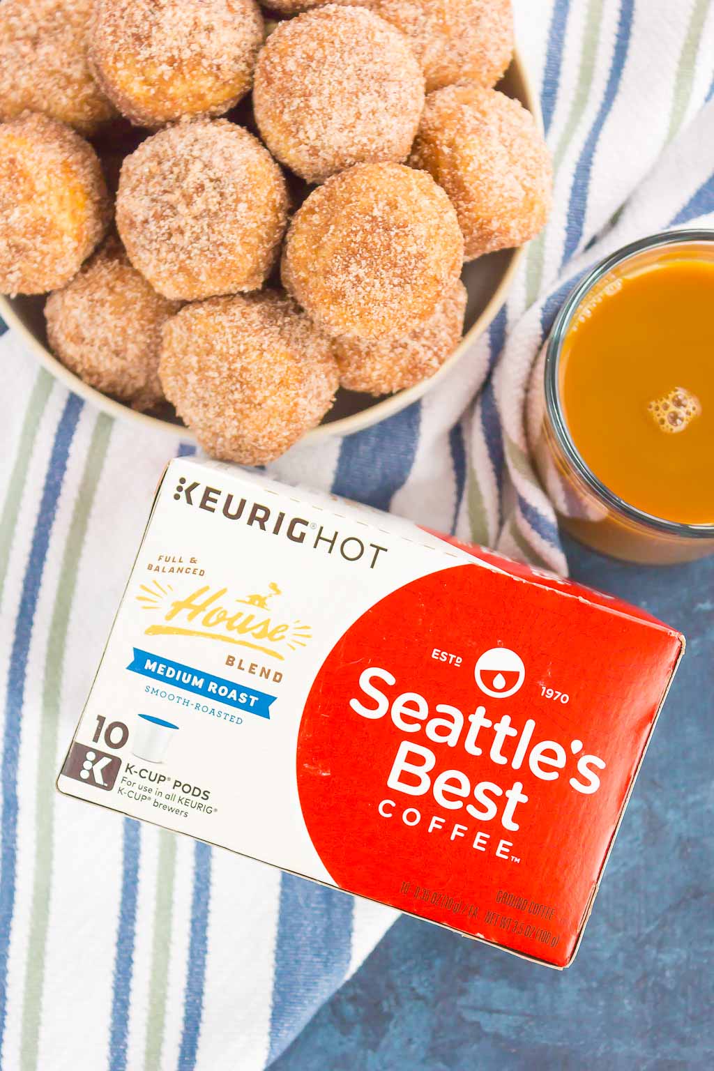 overhead view of cinnamon sugar baked donut holes piled in a white bowl next to a box of Seattle's Best k-cup pods 