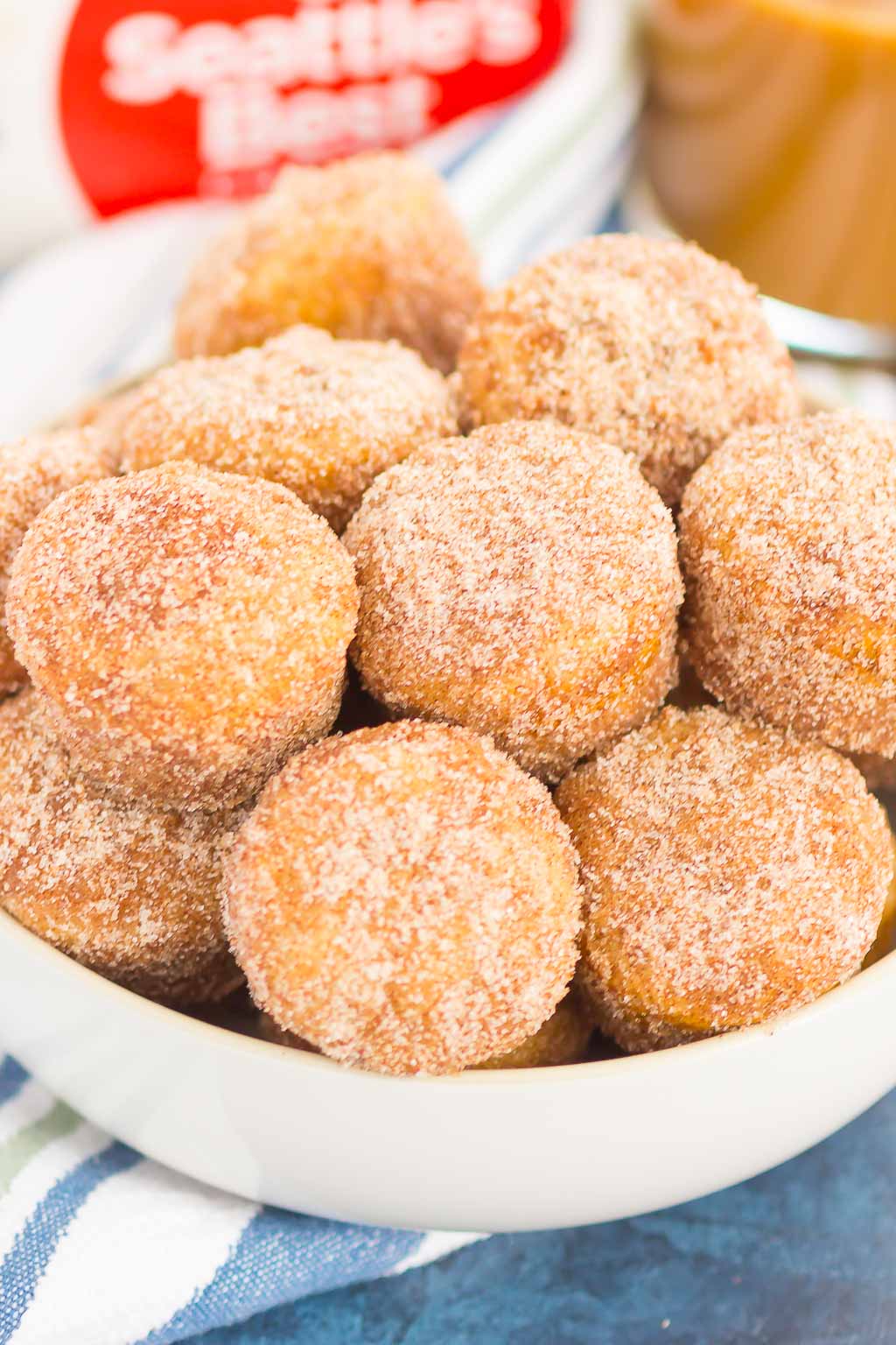 cinnamon sugar baked donut holes piled in a white bowl 