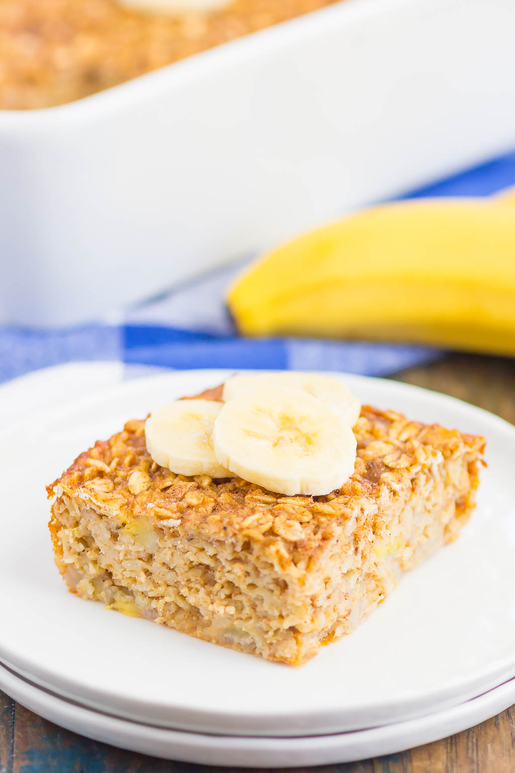 slice of banana baked oatmeal garnished with banana slices on white plate