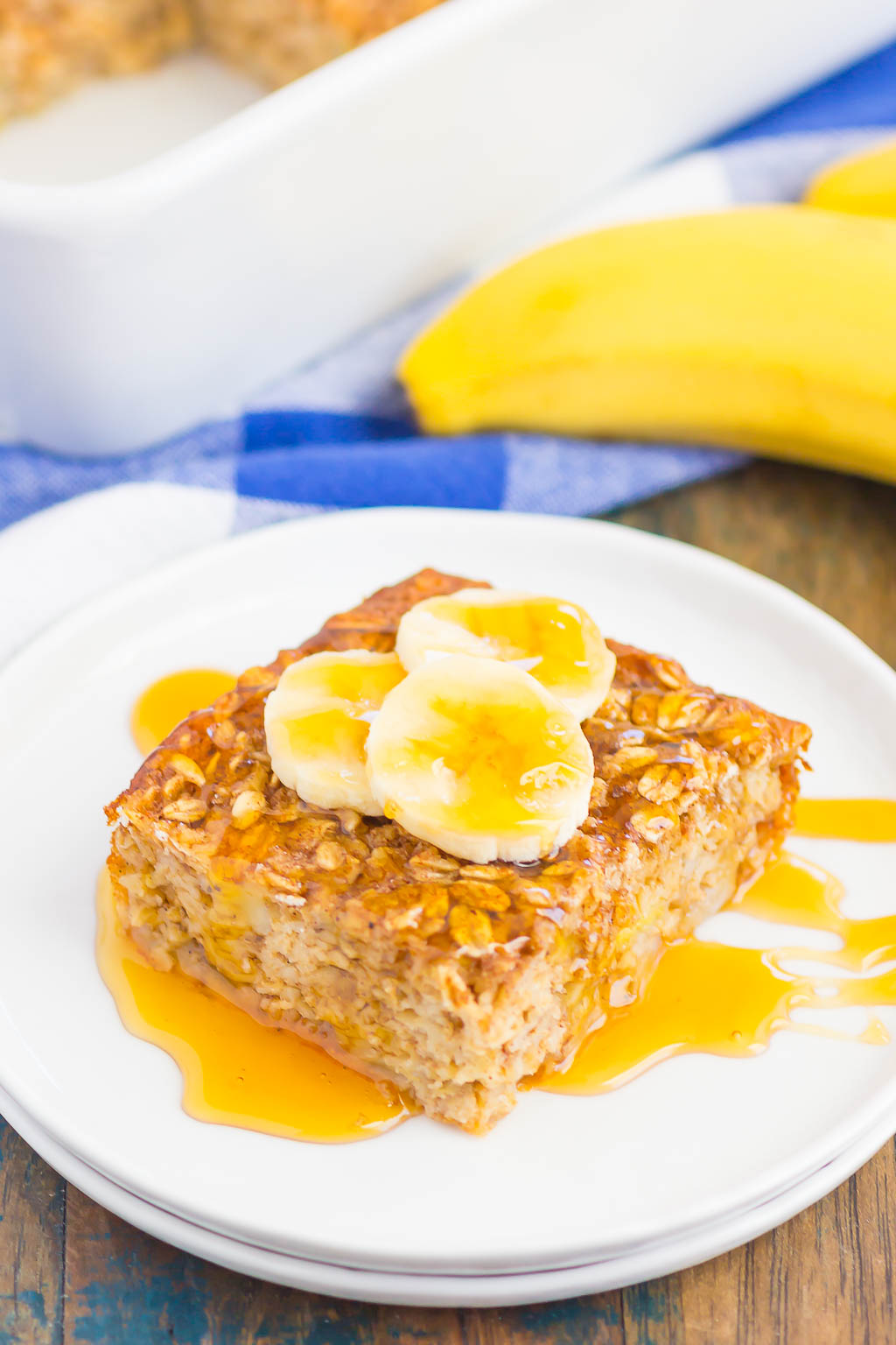 slice of banana baked oatmeal on white plate drizzled with honey