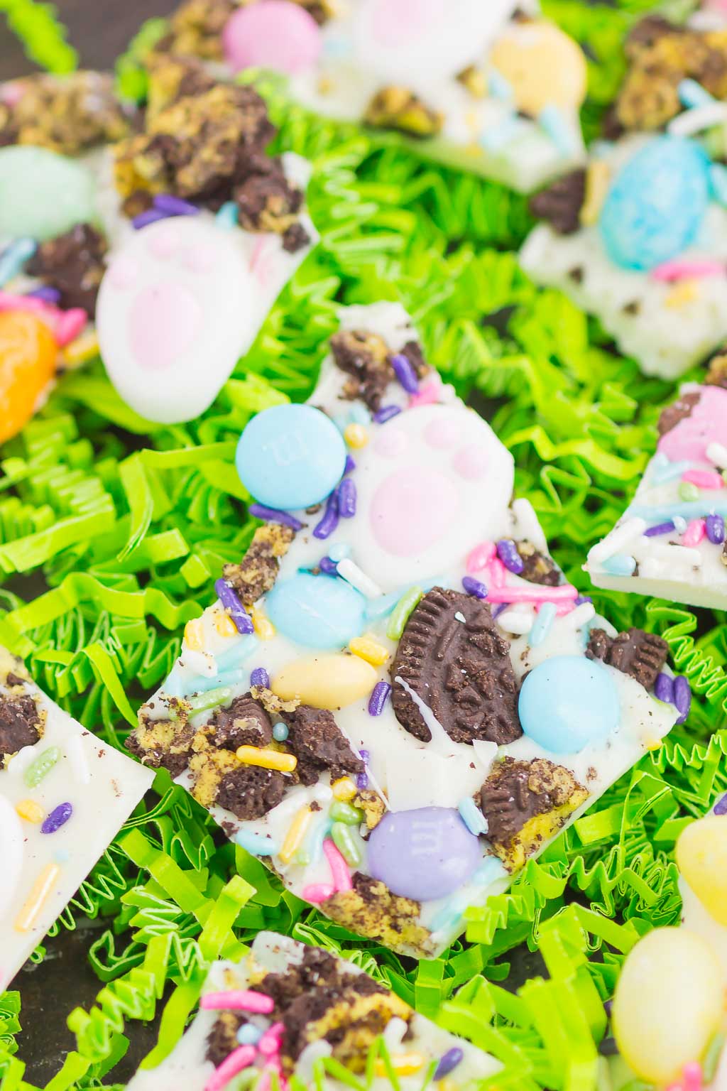 Pieces of Easter white chocolate bark on green confetti paper. 