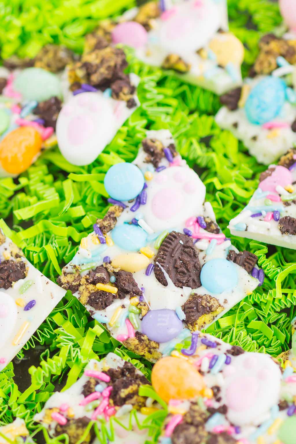 Pieces of Easter white chocolate bark on green confetti paper. 