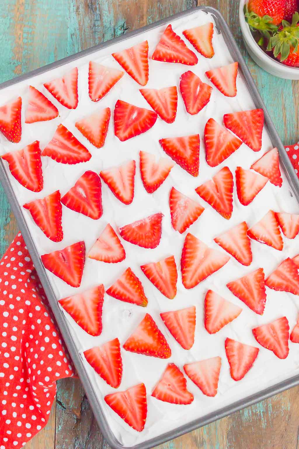 Overhead view of a strawberry jello poke cake in a glass baking dish. 