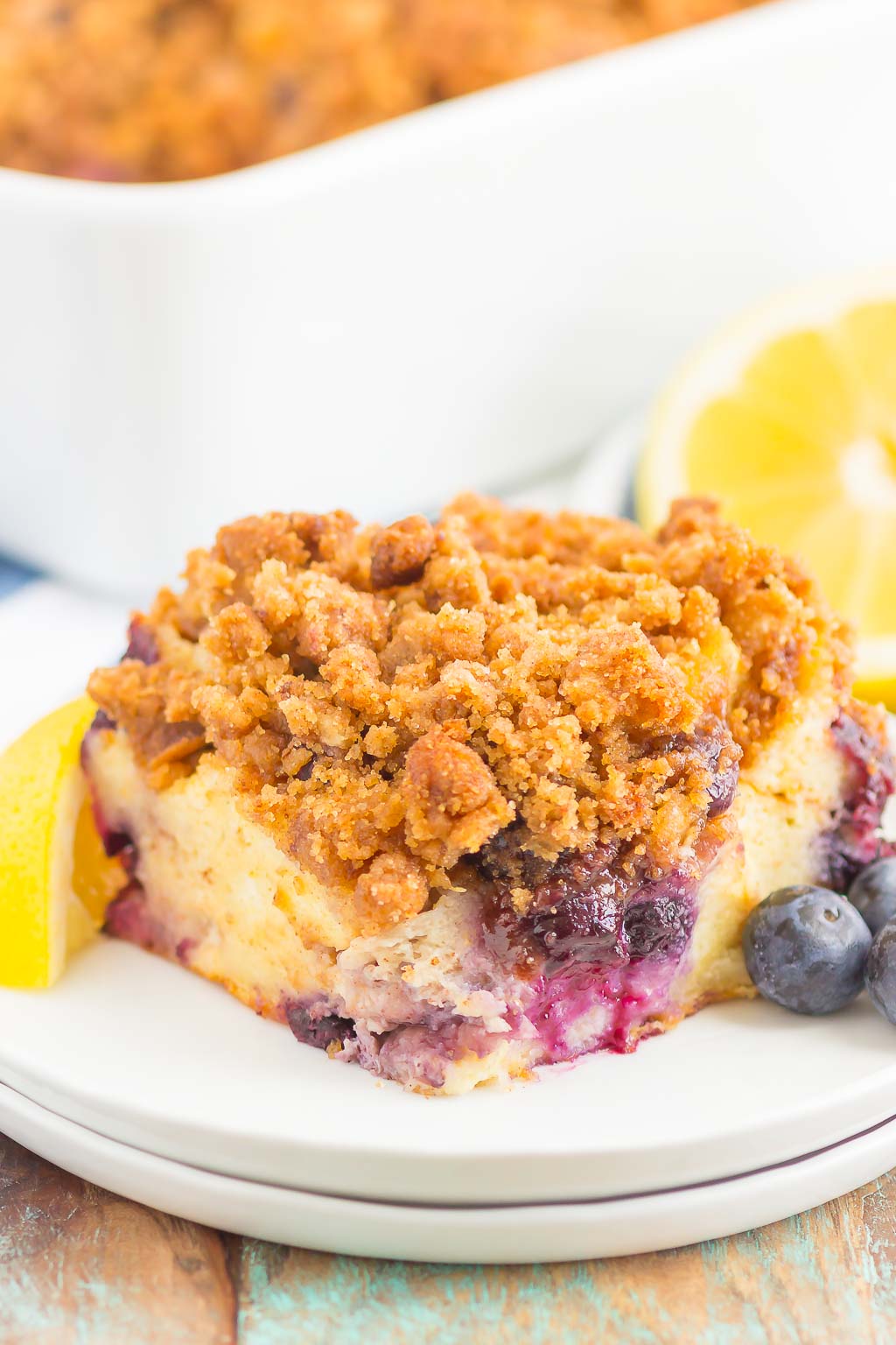 A slice of lemon blueberry french toast bake on a white dessert plate. 