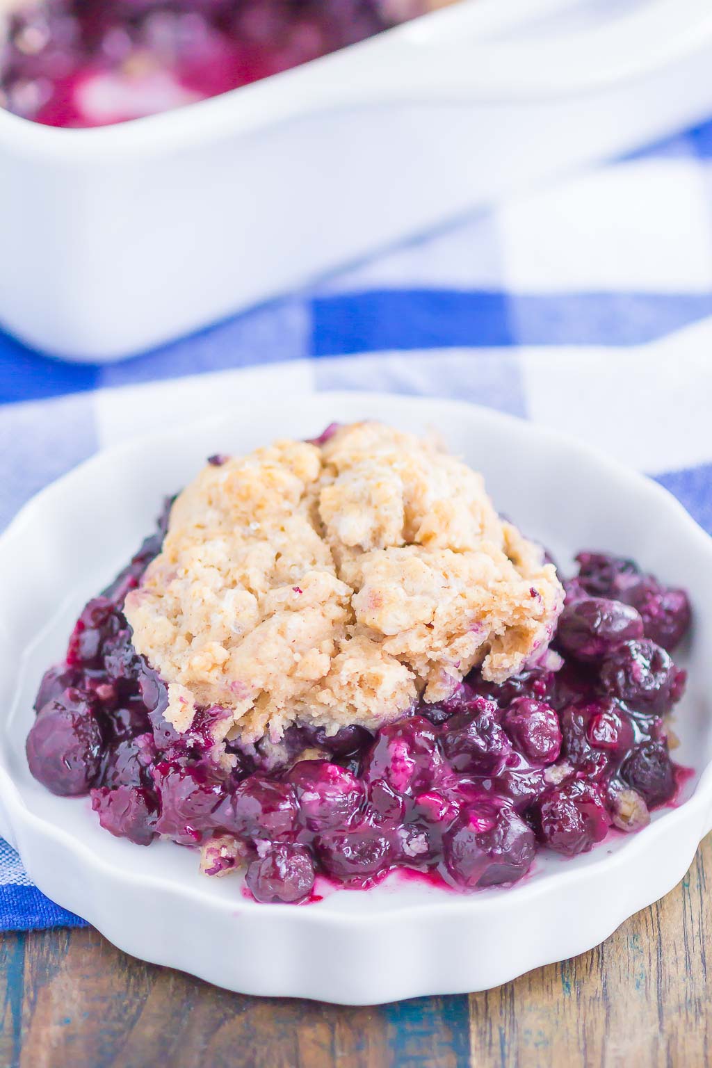 A portion of blueberry cobbler in a white dish. 