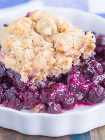 Easy Blueberry Cobbler is a simple dessert that's ready in no time. Tangy blueberries are tossed with cozy spices and then sprinkled with a buttery, cinnamon sugar cake-like topping. Easy to make and loaded with flavor, this cozy cobbler is perfect to enjoy all year long!