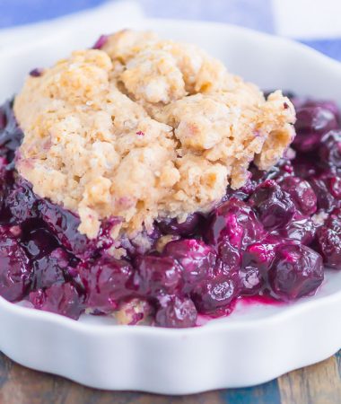 Easy Blueberry Cobbler is a simple dessert that's ready in no time. Tangy blueberries are tossed with cozy spices and then sprinkled with a buttery, cinnamon sugar cake-like topping. Easy to make and loaded with flavor, this cozy cobbler is perfect to enjoy all year long!