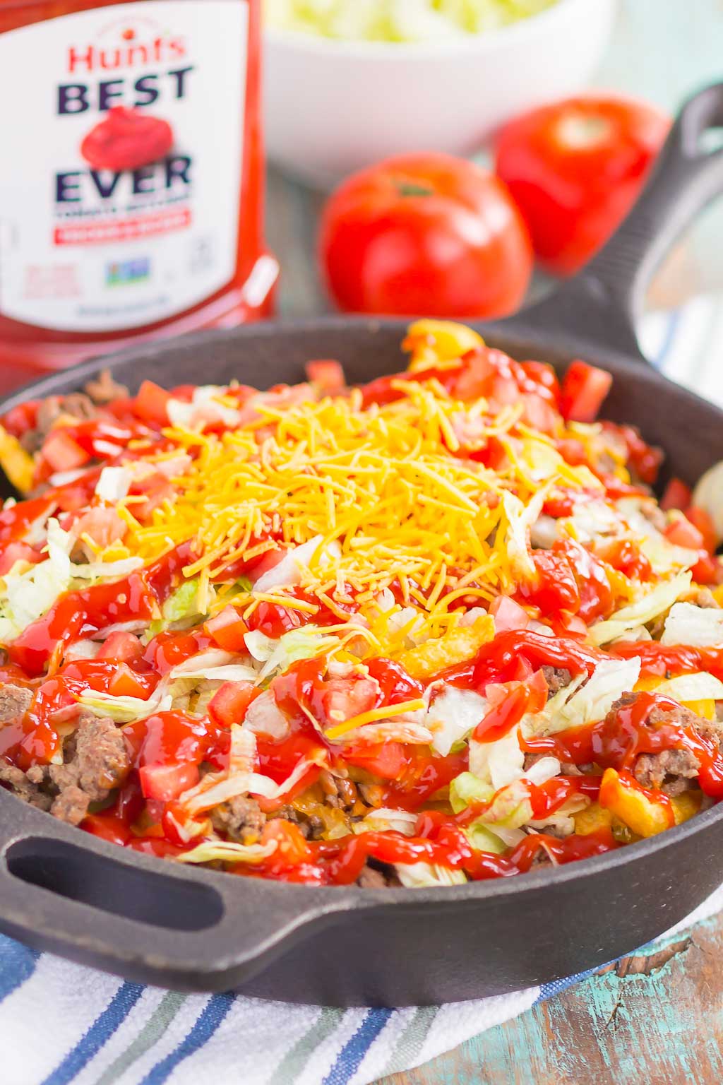 Loaded Cheeseburger Fries taste just like your favorite burger, but in appetizer form. These fries are topped with the classic ingredients of a cheeseburger and are baked to perfection. Easy to make and even better to eat, you'll love the crispy, crunchy, cheesy taste of this fun snack! #fries #cheeseburgerfries #loadedfries