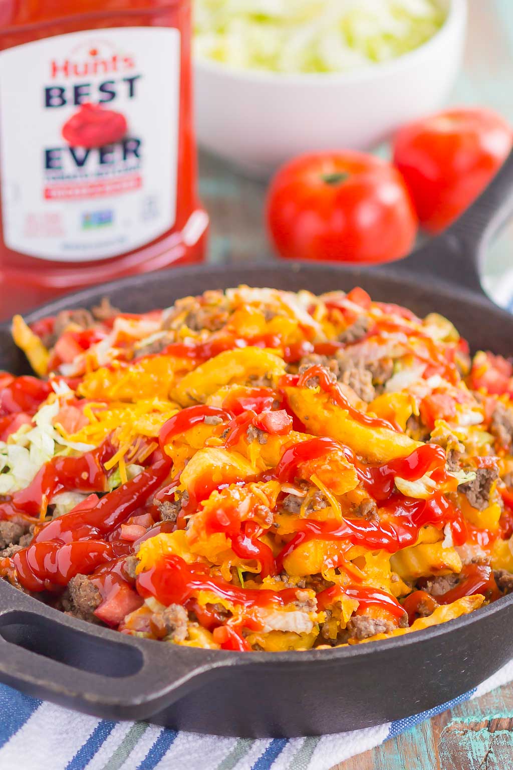 Loaded Cheeseburger Fries taste just like your favorite burger, but in appetizer form. These fries are topped with the classic ingredients of a cheeseburger and are baked to perfection. Easy to make and even better to eat, you'll love the crispy, crunchy, cheesy taste of this fun snack! #fries #cheeseburgerfries #loadedfries