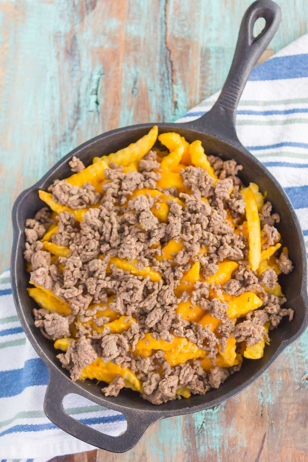 Loaded Cheeseburger Fries taste just like your favorite burger, but in appetizer form. These fries are topped with the classic ingredients of a cheeseburger and are baked to perfection. Easy to make and even better to eat, you'll love the crispy, crunchy, cheesy taste of this fun snack! #fries #cheeseburgerfries #loadedfries