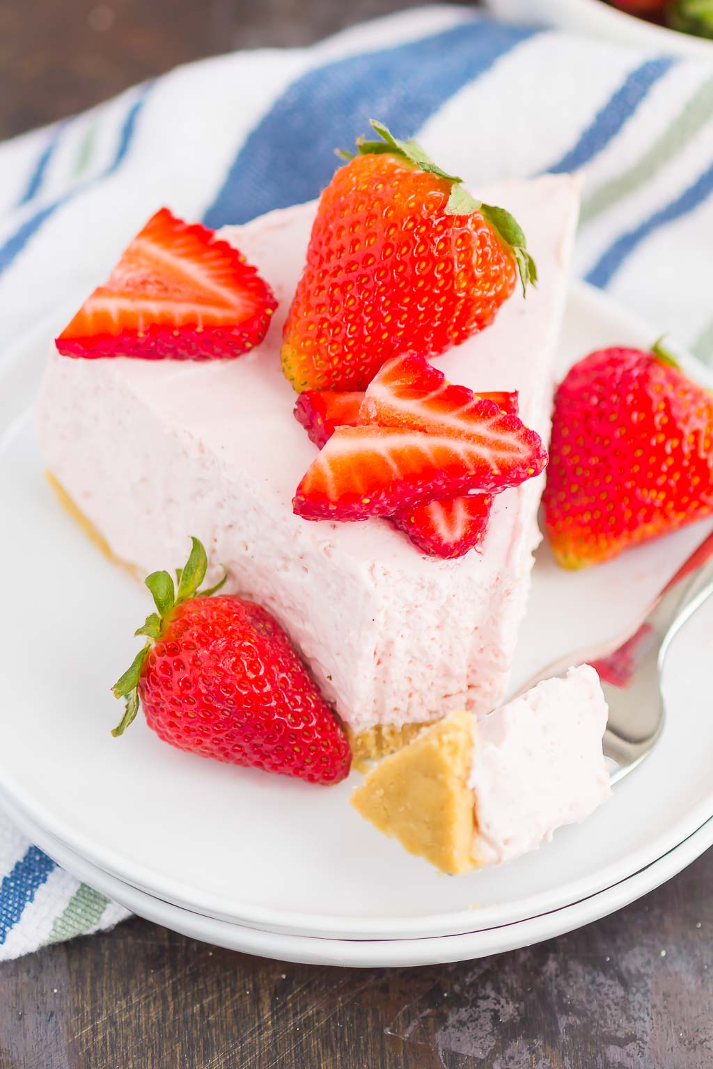 No Bake Strawberry Cheesecake is a simple dessert that's perfect for summer. A golden cookie crust is topped with a creamy strawberry cheesecake filling and then chilled to perfection. Easy to make and with no oven required, this decadent cake makes the most delicious treat!