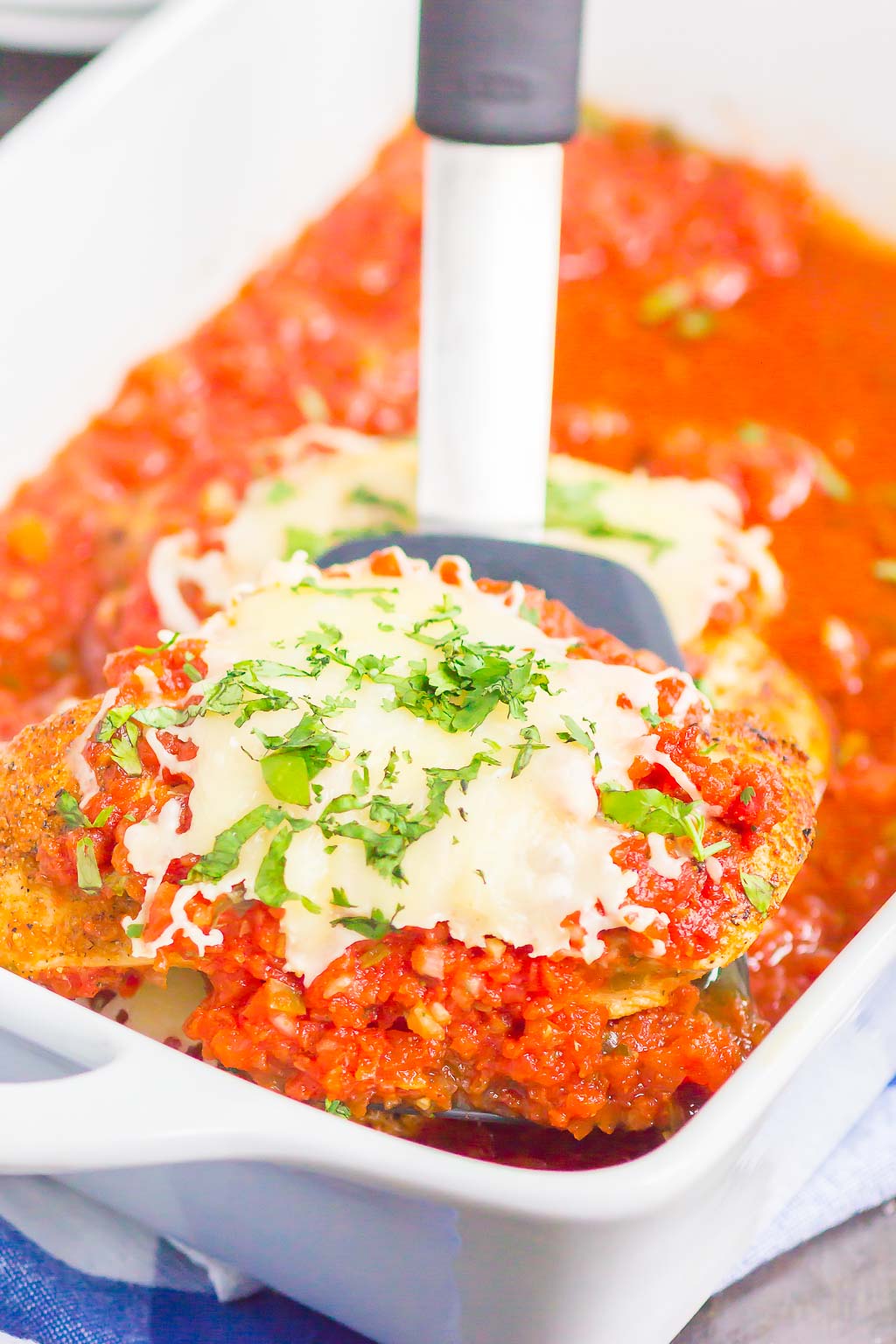 scooping out a Mexican chicken breast from baking dish