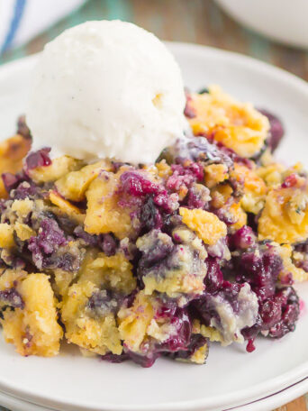 This Easy Blueberry Dump Cake is a delicious, three ingredient dessert that tastes just like your favorite cobbler. Simply dump everything in a pan, bake, and then get ready to wow your tastebuds. Perfect when served warm with a big scoop of vanilla ice cream!