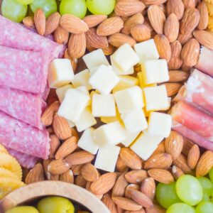 This Easy Cheese Board is the perfect appetizer that's ready in less than 10 minutes. With a delicious mix of meats, cheese, crackers, and more, this simple platter will wow just about everyone! #cheeseboard #cheeseplate #appetizer #snack #cheesyappetizer