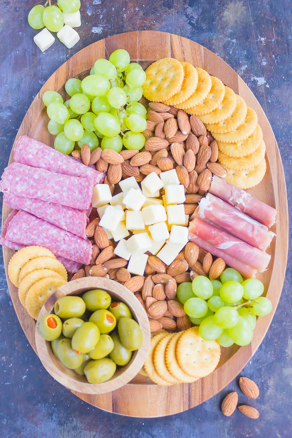 This Easy Cheese Board is the perfect appetizer that's ready in less than 10 minutes. With a delicious mix of meats, cheese, crackers, and more, this simple platter will wow just about everyone! #cheeseboard #cheeseplate #appetizer