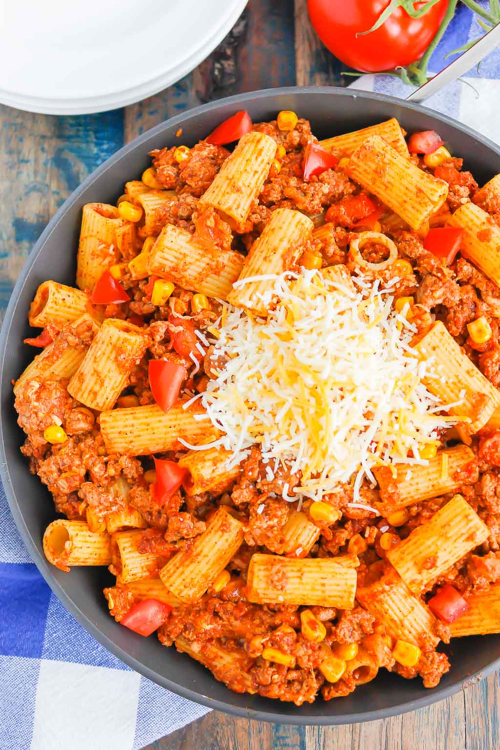 overhead view of chili pasta garnished with cheese in a skillet 
