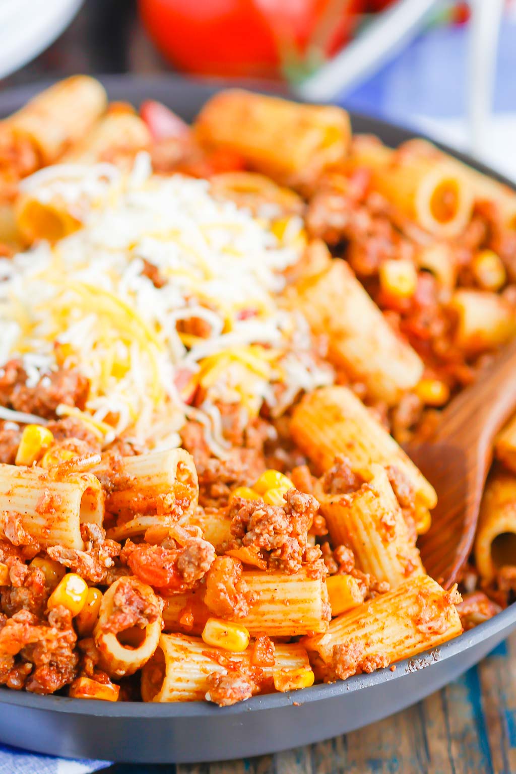 close up of chili pasta garnished with cheese in a skillet