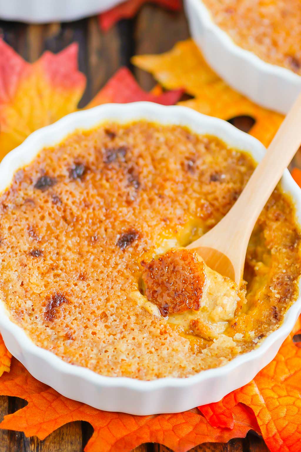 pumpkin creme brulee in a white ramekin with a wooden spoon