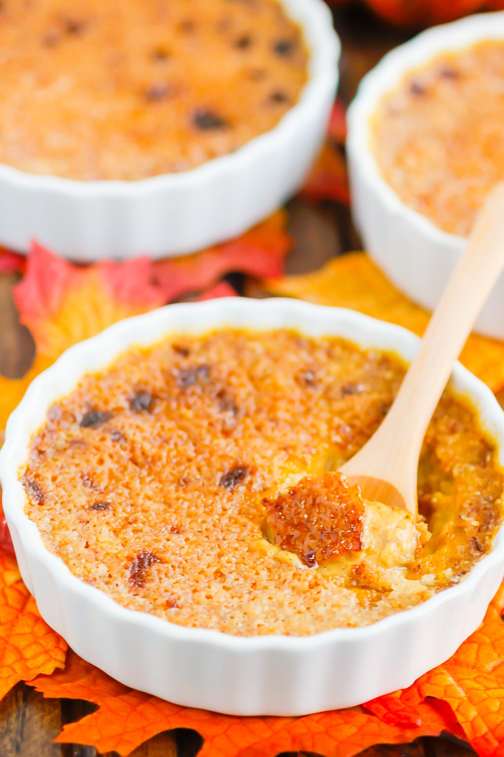 pumpkin creme brulee in a white ramekin with a wooden spoon