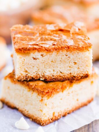 This White Chocolate Blondies Recipe combines the elegance of white chocolate with rich vanilla to bring you a delightfully sweet treat that is ready for the oven in minutes and baked in just half an hour.  Serve this recipe with a hot cup of coffee for the perfect treat on a cold day! #blondies #whitechocolate #whitechocolateblondies #blondierecipe #whitechocolatedessert #dessert #easydessert