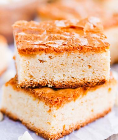 This White Chocolate Blondies Recipe combines the elegance of white chocolate with rich vanilla to bring you a delightfully sweet treat that is ready for the oven in minutes and baked in just half an hour.  Serve this recipe with a hot cup of coffee for the perfect treat on a cold day! #blondies #whitechocolate #whitechocolateblondies #blondierecipe #whitechocolatedessert #dessert #easydessert