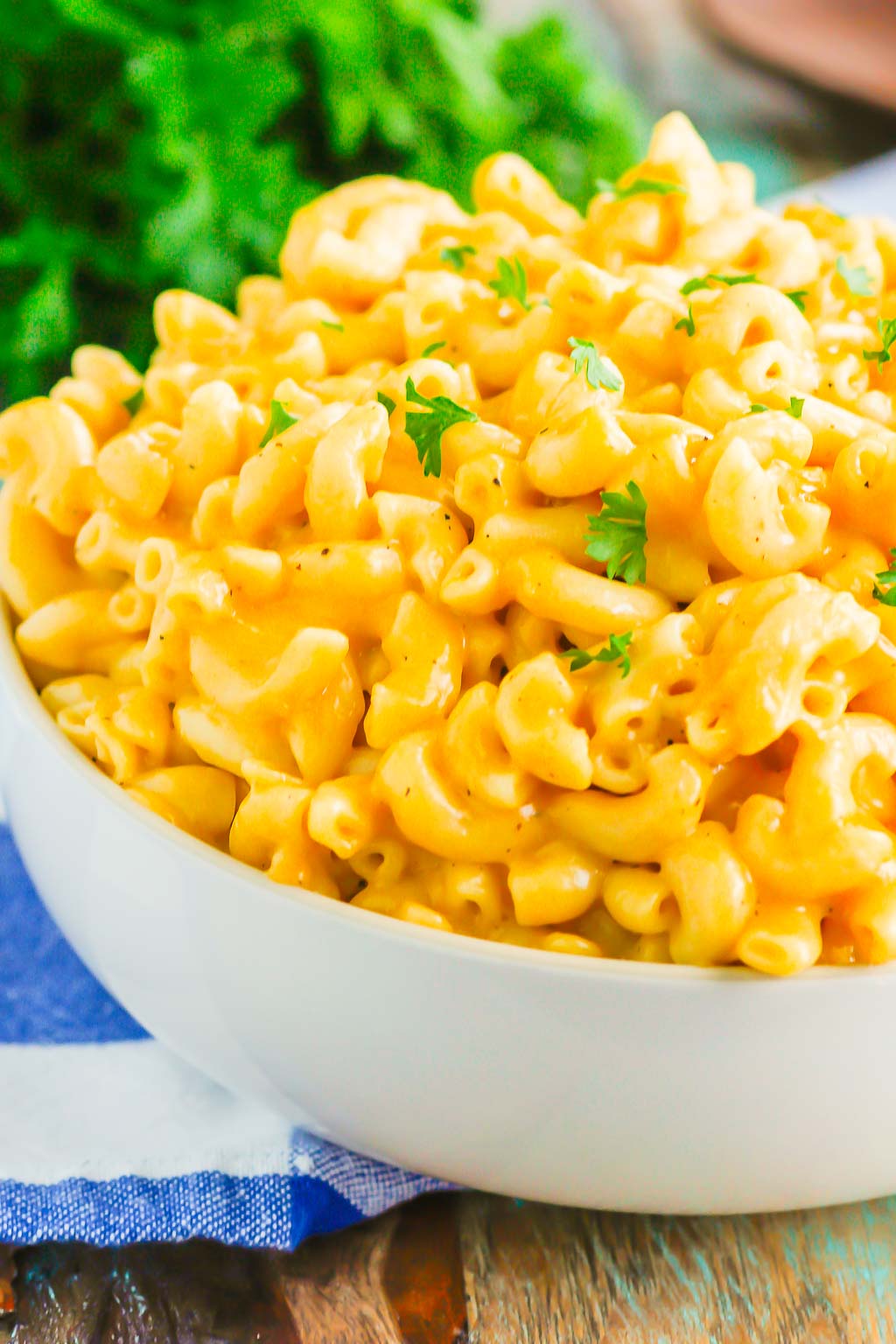 close up of instant pot mac and cheese garnished with parsley in white serving bowl