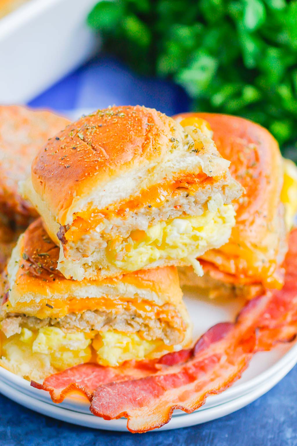 Breakfast Sliders are an easy, make-ahead dish that's filled with your favorite ingredients. Scrambled eggs, crispy bacon, sausage and cheese are loaded into a slider roll and then topped with a garlic butter glaze. Perfect to serve for a crowd or for when you need breakfast on-the-go!