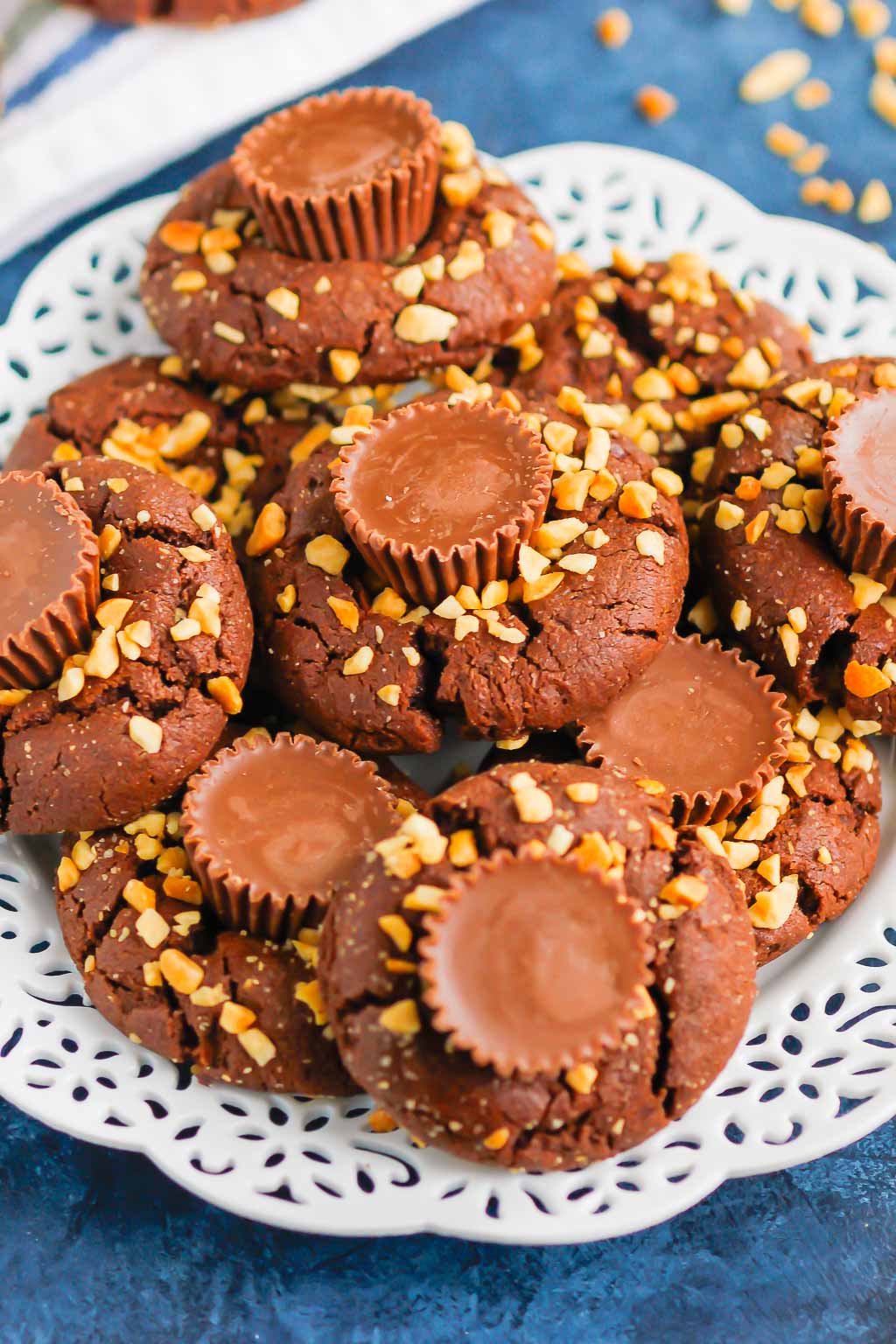 This fun spin on Chocolate Peanut Butter Blossoms adds even more chocolate and peanut butter flavor in every bite. This easy cookie recipe is soft, chewy, and all around delicious! #cookies #chocolatecookies #peanutbuttercookies #peanutbutterblossoms #blossomcookies #cookierecipe #holidaycookies #christmascookies #dessert