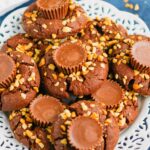 This fun spin on Chocolate Peanut Butter Blossoms adds even more chocolate and peanut butter flavor in every bite. This easy cookie recipe is soft, chewy, and all around delicious! #cookies #chocolatecookies #peanutbuttercookies #peanutbutterblossoms #blossomcookies #cookierecipe #holidaycookies #christmascookies #dessert