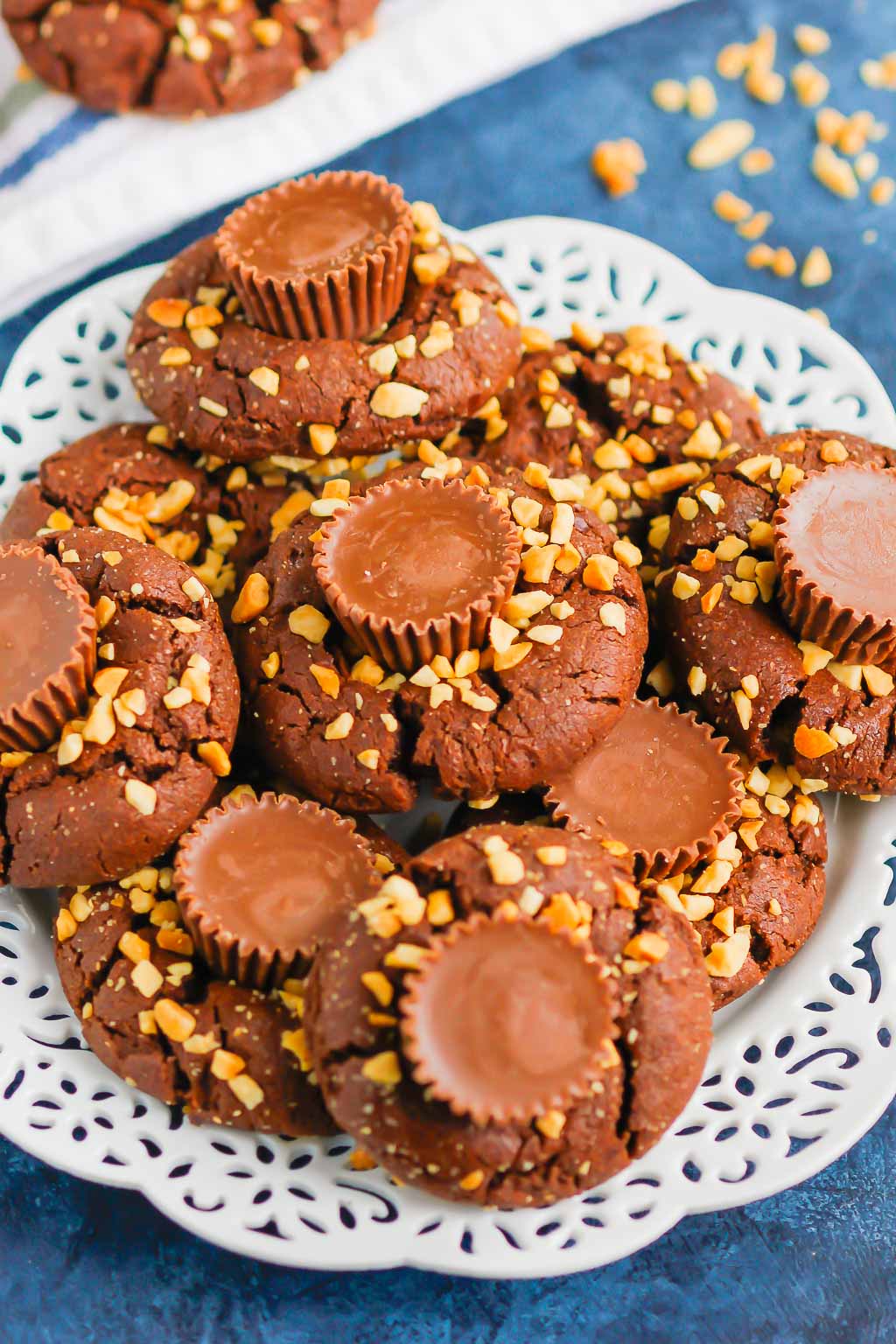 This fun spin on Chocolate Peanut Butter Blossoms adds even more chocolate and peanut butter flavor in every bite. This easy cookie recipe is soft, chewy, and all around delicious! #cookies #chocolatecookies #peanutbuttercookies #peanutbutterblossoms #blossomcookies #cookierecipe #holidaycookies #christmascookies #dessert