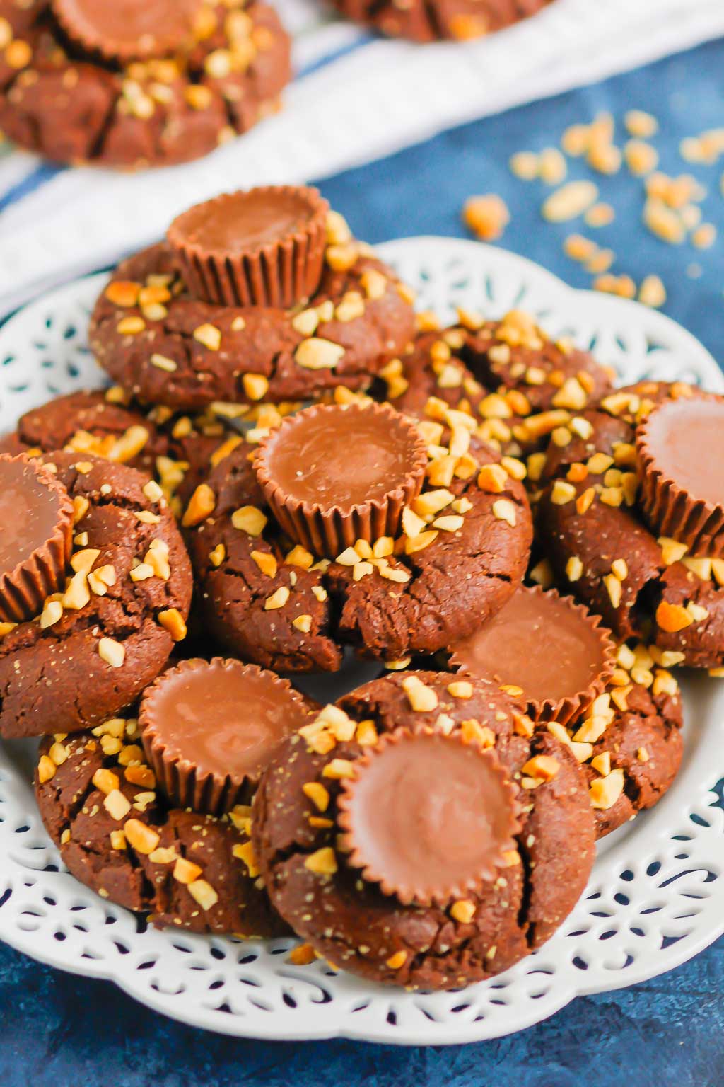 This fun spin on Chocolate Peanut Butter Blossoms adds even more chocolate and peanut butter flavor in every bite. This easy cookie recipe is soft, chewy, and all around delicious! #cookies #chocolatecookies #peanutbuttercookies #peanutbutterblossoms #blossomcookies #cookierecipe #holidaycookies #christmascookies #dessert