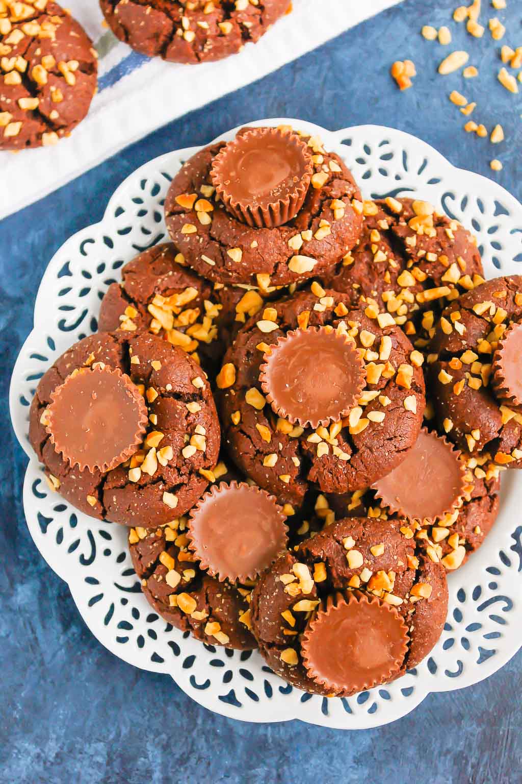 This fun spin on Chocolate Peanut Butter Blossoms adds even more chocolate and peanut butter flavor in every bite. This easy cookie recipe is soft, chewy, and all around delicious! #cookies #chocolatecookies #peanutbuttercookies #peanutbutterblossoms #blossomcookies #cookierecipe #holidaycookies #christmascookies #dessert