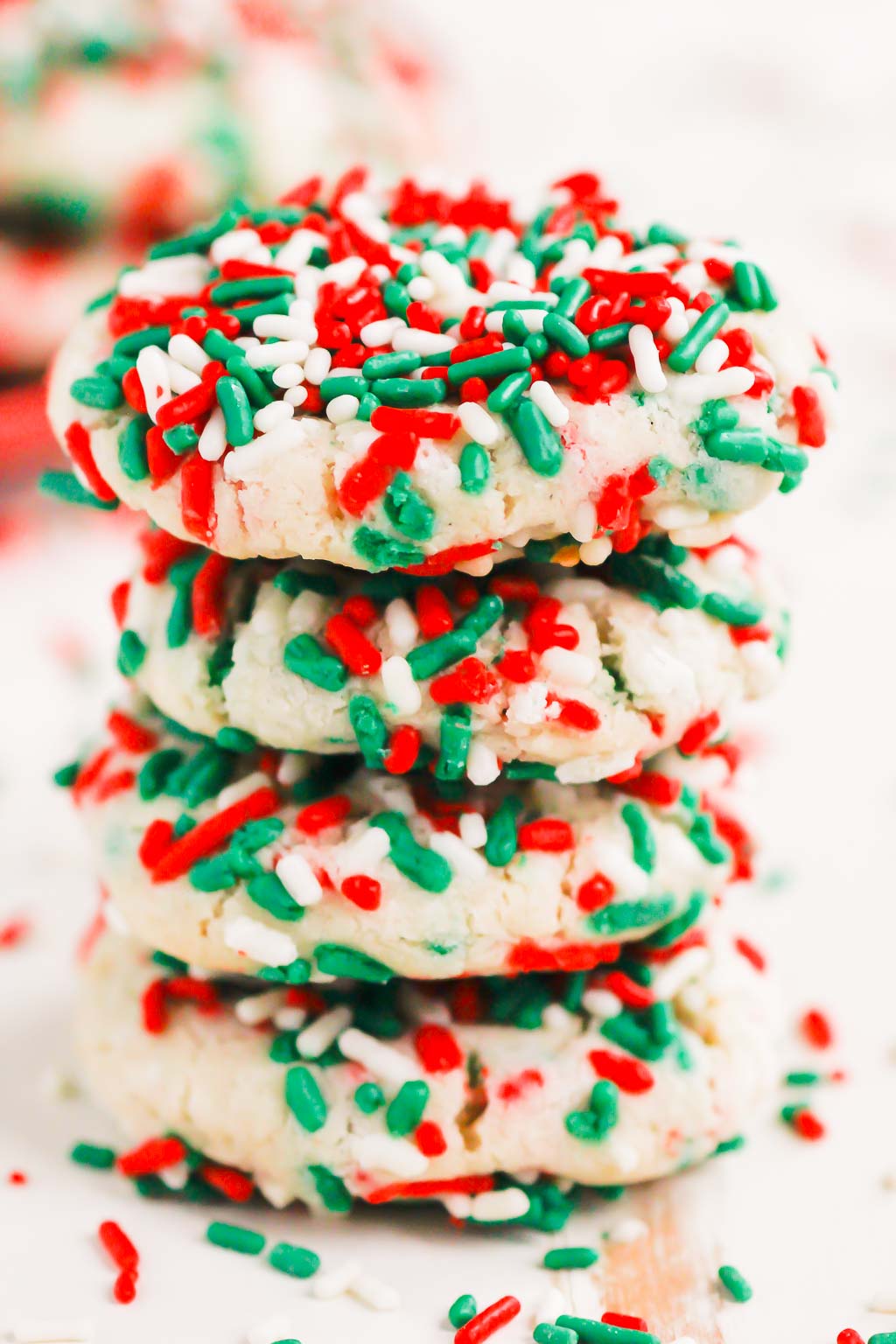 a stack of four sugar cookies with sprinkles. 