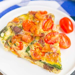 This Bacon and Tomato Frittata is a simple dish that's ready in less than an hour. Filled with crisp bacon, tender mushrooms, spinach and tomatoes, this recipe makes a delicious breakfast or brunch! #frittata #frittatarecipe #easyfrittata #bacon #baconfrittata #tomatofrittata #mushroomfrittata #breakfast #easybreakfast #breakfastrecipe