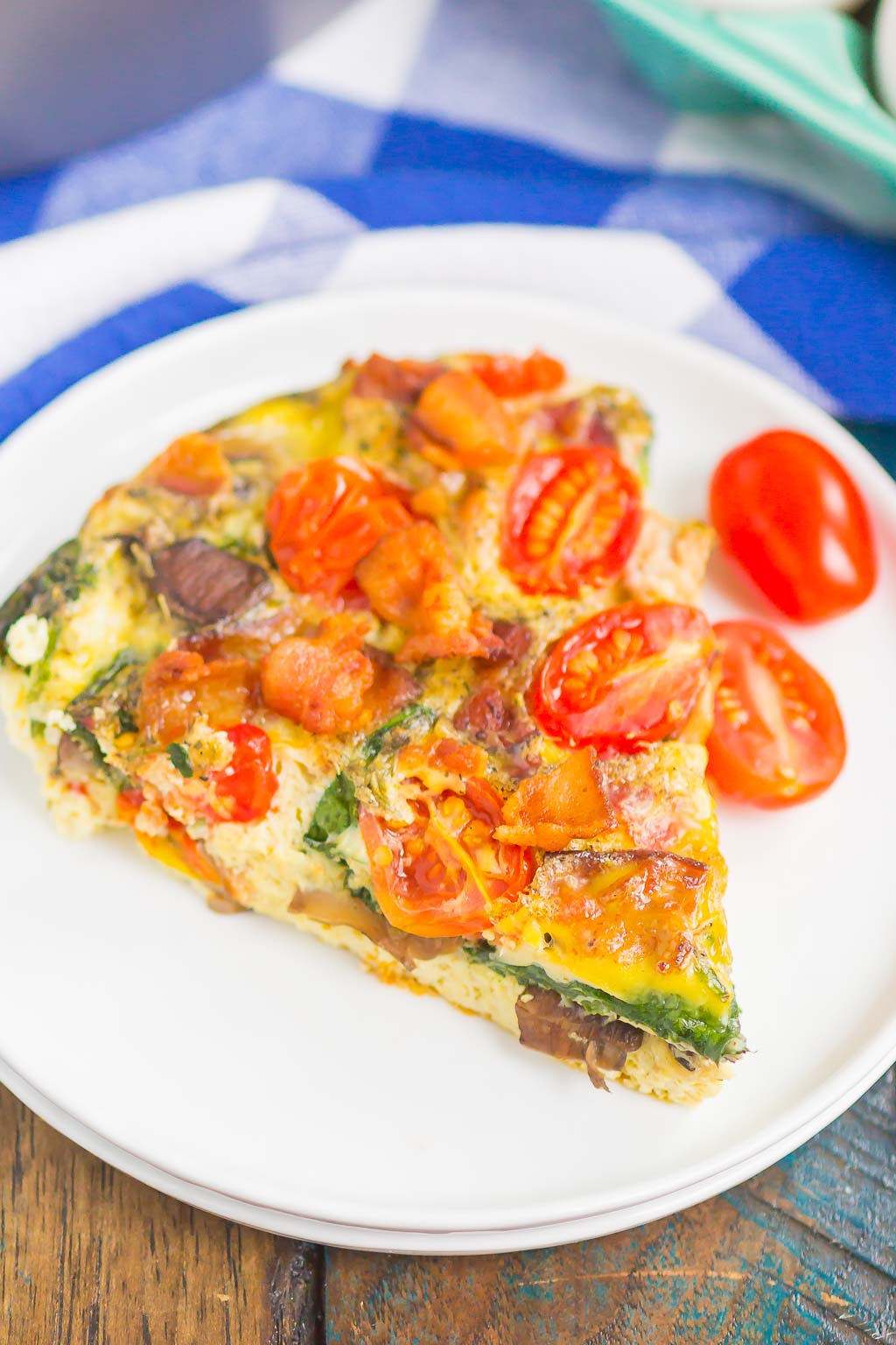 This Bacon and Tomato Frittata is a simple dish that's ready in less than an hour. Filled with crisp bacon, tender mushrooms, spinach and tomatoes, this recipe makes a delicious breakfast or brunch! #frittata #frittatarecipe #easyfrittata #bacon #baconfrittata #tomatofrittata #mushroomfrittata #breakfast #easybreakfast #breakfastrecipe