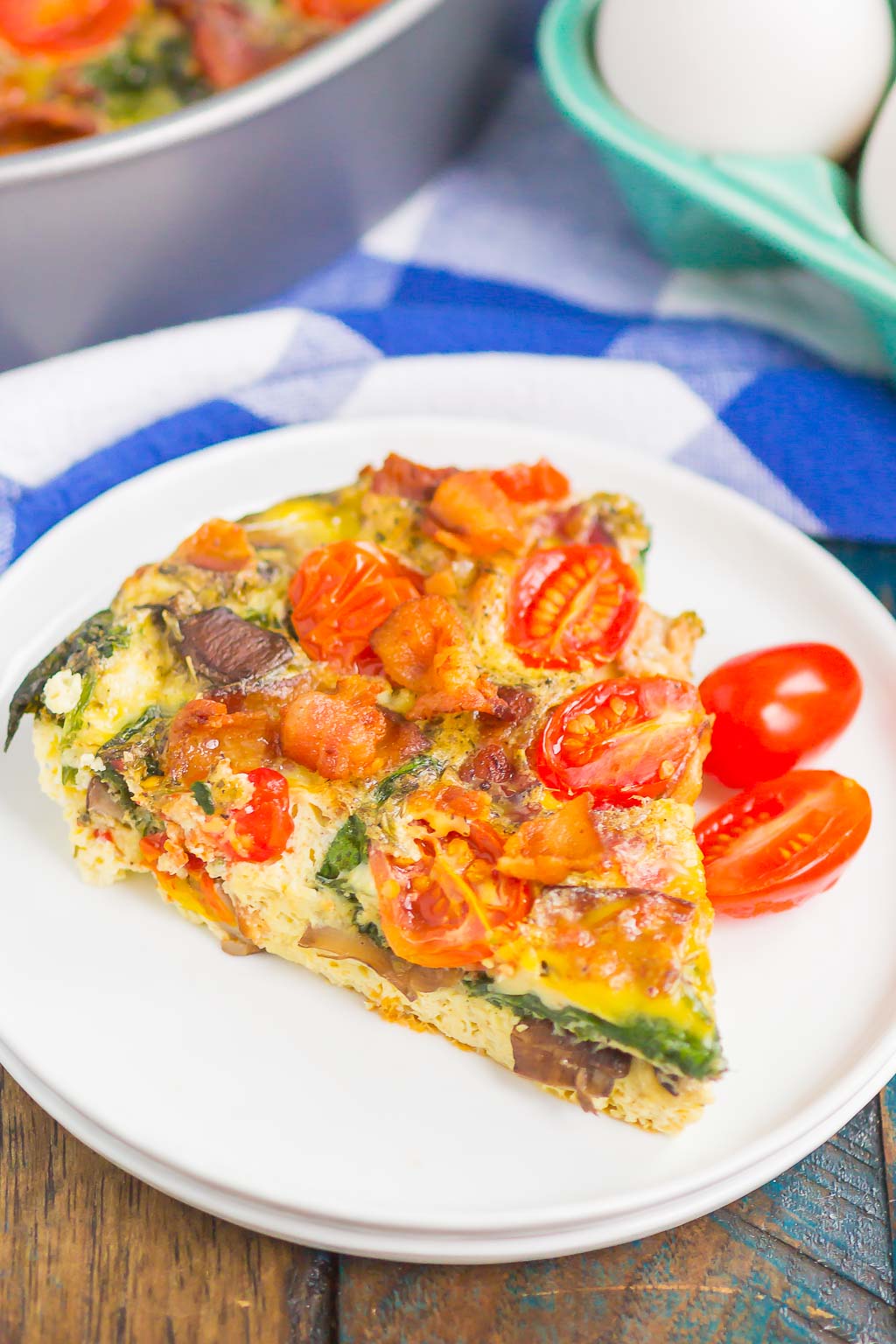 This Bacon and Tomato Frittata is a simple dish that's ready in less than an hour. Filled with crisp bacon, tender mushrooms, spinach and tomatoes, this recipe makes a delicious breakfast or brunch! #frittata #frittatarecipe #easyfrittata #bacon #baconfrittata #tomatofrittata #mushroomfrittata #breakfast #easybreakfast #breakfastrecipe