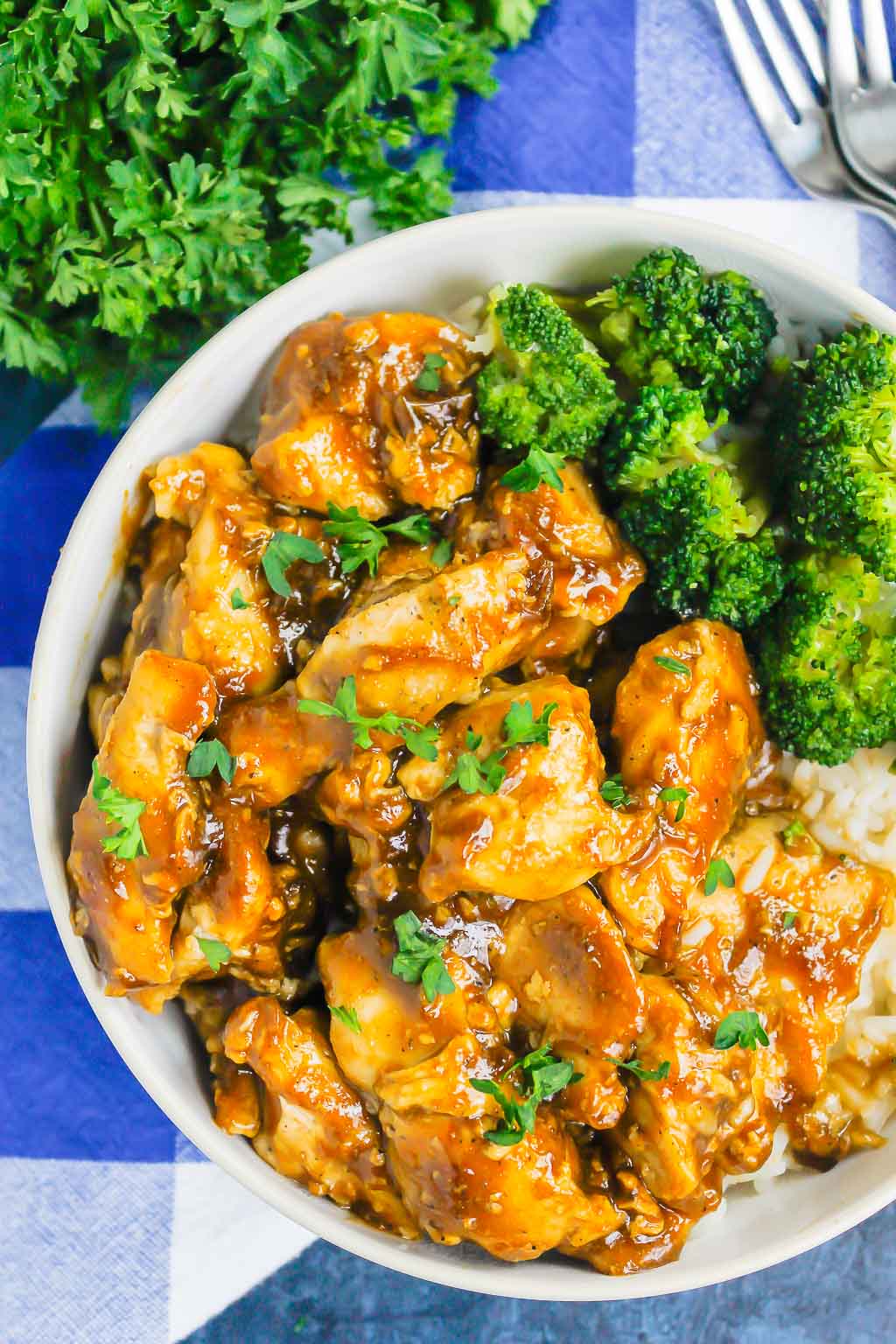 Overhead view of a white bowl with homemade teriyaki chicken, white rice, and broccoli. 