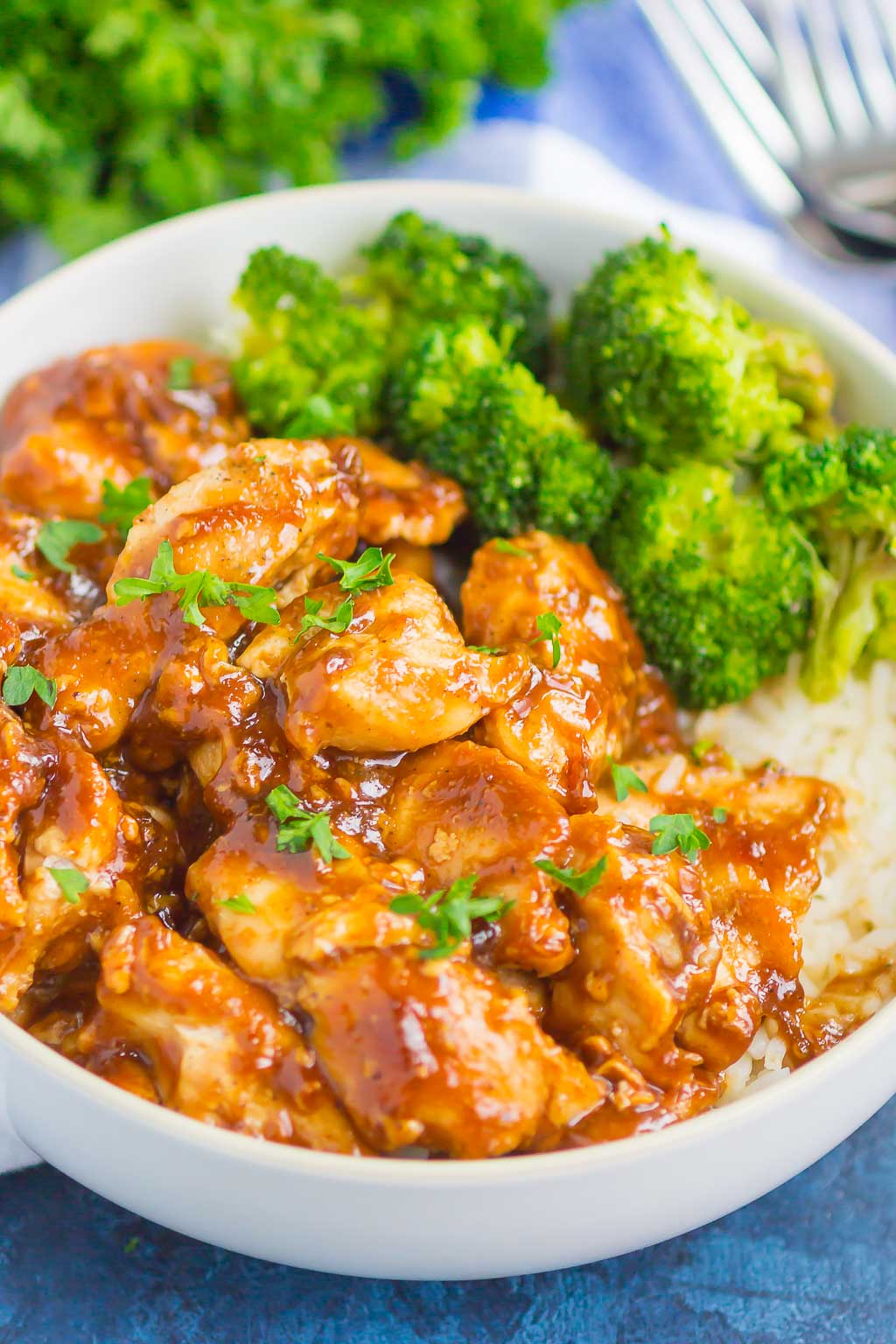 A white bowl with easy teriyaki chicken, white rice, and broccoli. 