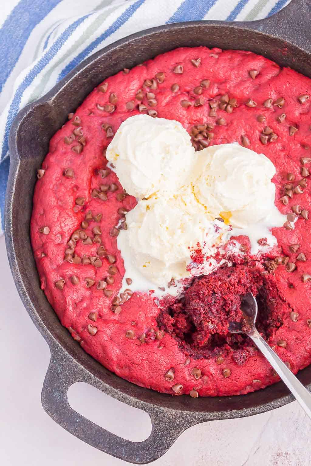 Red Velvet Skillet Cookie is thick and chewy, with a warm, gooey center. Baked in a skillet and topped with chocolate chips, you'll want to dig in with a big scoop of vanilla ice cream!