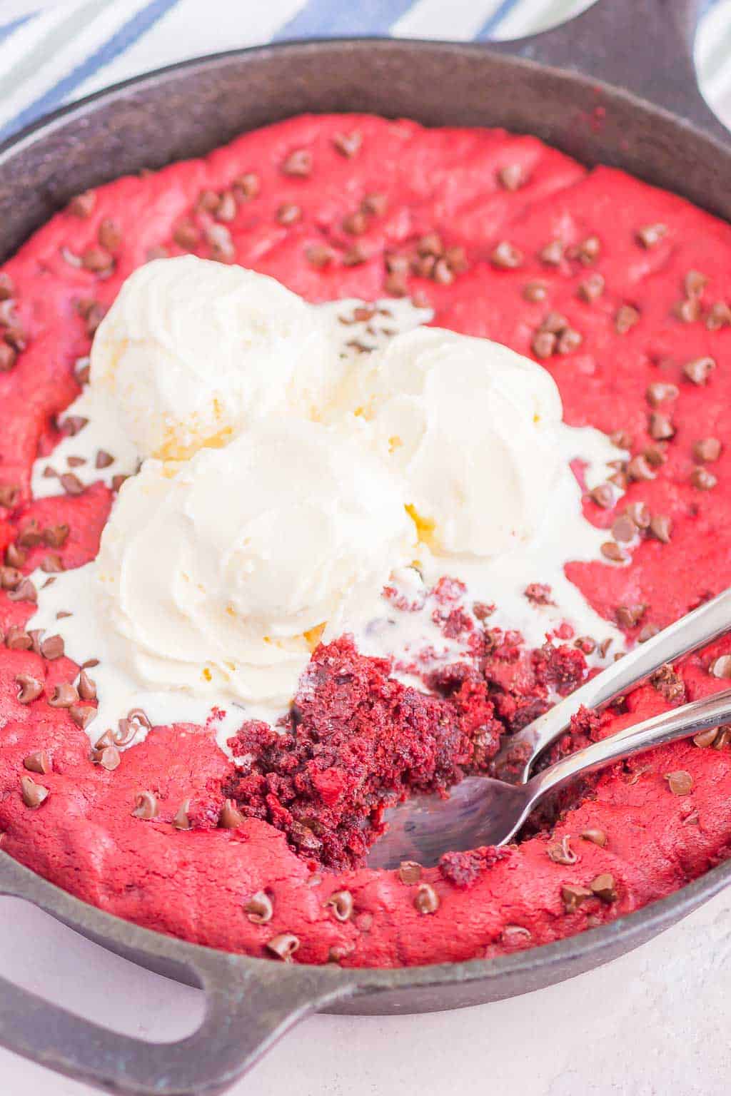 Red Velvet Skillet Cookie is thick and chewy, with a warm, gooey center. Baked in a skillet and topped with chocolate chips, you'll want to dig in with a big scoop of vanilla ice cream!